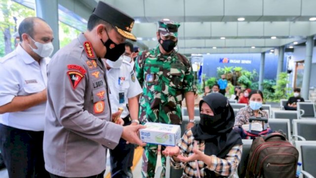Kapolri Jenderal Pol Listyo Sigit Prabowo, memberi masker kepada salah satu Pemudik yang melalui Stasiun Pasar Senen saat meninjau kesiapan Arus Mudik 2022, Rabu (20/04/2022). (Istimewa)