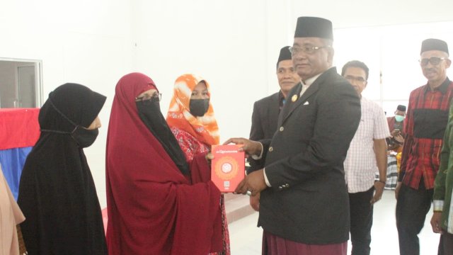 Bupati Buteng H. Samahuddin, SE saat menyerahkan Al-Qur'an kepada beberapa guru TPQ di Kecamatan Mawasangka, Kamis (07/04/2022).