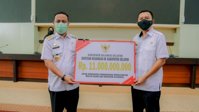 Gubernur Sulsel Andi Sudirman Sulaiman, menyerahkan bantuan keuangan secara sembolis kepada Bupati Selayar Muhammad basil Ali, Rabu (27/04/2022). (Istimewa)