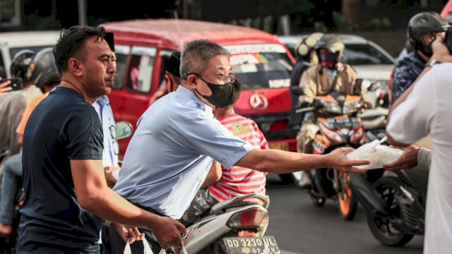 Penjabat Direktur Utama PDAM Kota Makassar Beni Iskandar, memberikan takjil kepada Pengendara di Jalan Ratulangi, Kota Makassar. (Istimewa)