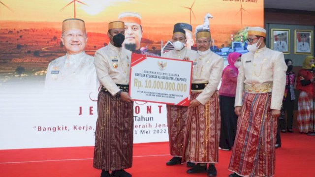Gubernur Sulsel Andi Sudirman Sulaiman, menyerahkan bantuan keuangan Pemprov Sulsel secara simbolis kepada Bupati Jeneponto Iksan Iskandar, Minggu (01/05/2022). (Istimewa)