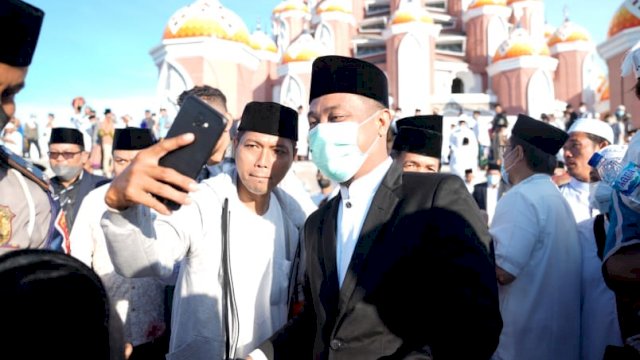 Seorang warga berswafoto dengan Gubernur Sulsel Andi Sudirman Sulaiman, usai Salat Idul Fitri di Pelataran Masjid 99 Kubah Makassar, Senin (02/5/2022). (Istimewa)