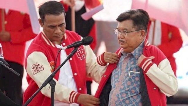 Ketua IKA Unhas 2022-2026 Andi Amran Sulaiman, memakaikan Jaket IKA Unhas kepada Mantan Ketua IKA Unhas yang juga mantan Wakil Presiden Dua Periode Jusuf Kalla, Sabtu (14/05/2022). (Istimewa)