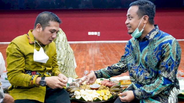Gubernur Sulsel Andi Sudirman Sulaiman, berbincang akrab dengan Ketua Umum Permas Syamsu Rizal, sambil menikmati sajian kue tradisional, pada acara Silaturahim Nasional Dewan Pengurus Pusat (DPP) Persatuan Masyarakat Selayar (Permas) di Ruang Ballroom Teater, Lantai 3, Menara Phinisi UNM, Minggu (15/05/2022). (Istimewa)