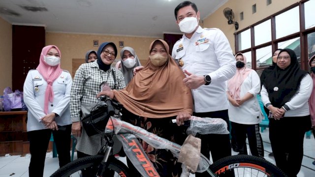 Salah satu warga Kabupaten Gowa saat menerima hadiah sepeda usai mengikuti Gebyar Vaksin Covid-19. (Istimewa)