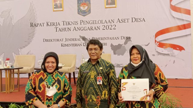 Kepala Dinas Pemberdayaan Masyarakat dan Desa Kabupaten Luwu Utara melalui Kabid Pemerintahan Desa, Fatimah Mursalim, mwnerima penghargaan dari Dirjen Bina Pemerintahan Desa Kementerian Dalam Negeri, Yushanto Huntoyungo. (Istimewa)