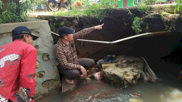 Ketua DPRD Luwu Timur, Aripin didampingi kepala desa dan tokoh masyarakat desa Matompi melihat kondisi jalan yang hampir putus.