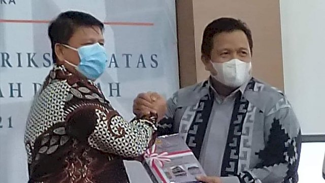 Bupati Muna Laode Muhammad Rusman Emba, saat menerima penghargaan WTP Kepala Badan Pemeriksaan Keuangan (BPK) Republik Indonesia (RI) Perwakilan Provinsi Sultra Patrice Lumumba Sihombing, di Kota Kendari, Kamis (02/06/2022). (Istimewa)