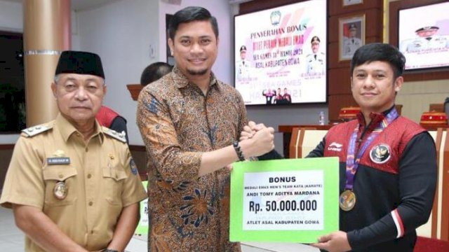 Bupati Gowa Adnan Purichta Ichsan, didampingi Wakil Bupati Gowa Abd Rauf Malaganni, saat menyerahkan bonus secara simbolik kepada atlet berprestasi di Baruga Karaeng Galesong, Kantor Bupati Gowa, Senin (06/06/2022). (Dok. Humas Gowa)