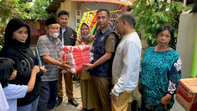 Petugas dari Dinas Sosial Provinsi Sulawesi Selatan, menyalurkan bantuan ke Korban Kebakaran di Jalan Maccini, Kota Makassar, Senin (06/06/2022). (Istimewa)