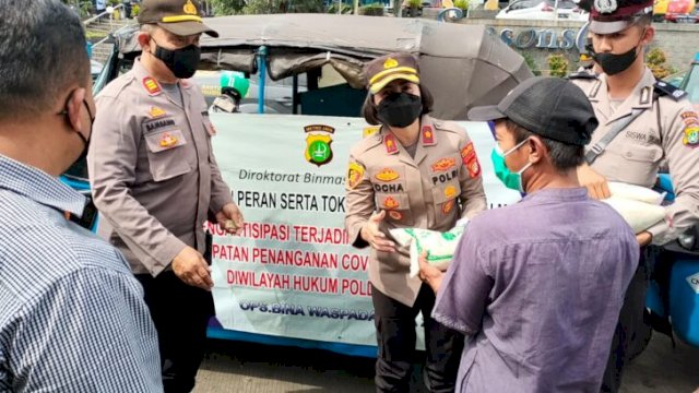 Kapolsek Tambora Jakarta Barat Kompol Rosana Albertina Labobar, saat menyerahkan bantuan sembako kepada Sopir Bajaj, Sabtu (11/06/2022). (Istimewa)