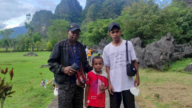 Anggota DPRD Kabupaten Kepulauan Yapen, Simson Auray bersama dua orang anak mengunjungi wisata Taman Prasejarah Leang-Leang yang ada di dalam wilayah Taman Nasional Bantimurung Bulusaraung, Kabupaten Maros, Sulawesi Selatan. Minggu (19/06/2022). (Foto: Wawan Setiawan)