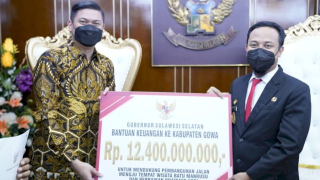 Gubernur Sulawesi Selatan Andi Sudirman Sulaiman, menyerahkan bantuan keuangan secara simbolis kepada Bupati Gowa Adnan Purichta Ichsan, Senin (20/06/2022). (Istimewa)
