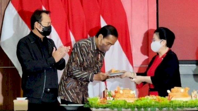 Tampak mesra, ketua umum PDIP Megawati Soekarnoputri memberikan potongan tumpeng ke Presiden Jokowi, Selasa (21/06/2022). (Ist)
