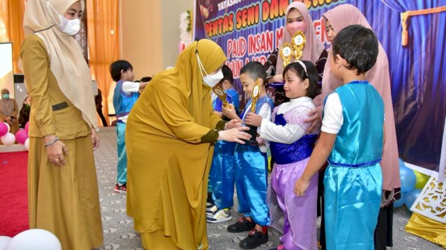 Ketua Tim Penggerak PKK Sulsel Naoemi Octarina, menyerahkan Tropi kepada murid PAUD saat menghadiri Pentas Seni dan Penamatan PAUD Insan Masagena Tahun Ajaran 2021 - 2022, Senin (20/06/2022). (Istimewa)