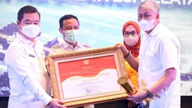 Gubernur Sulawesi Selatan Andi Sudirman Sulaiman, menyerahkan Piala dan Piagam penghargaan kepada Bupati Pinrang Irwan Hamid, Rabu (30/3/2022). (Istimewa)