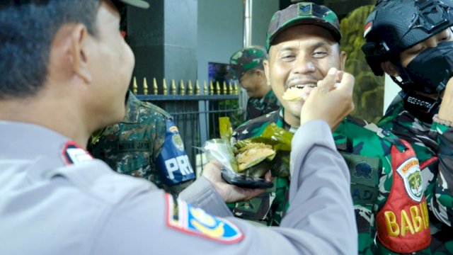 Anggota Polsek Cengkareng memberikan suapan kepada Anggota Koramil 04 Cengkareng. (Istimewa)