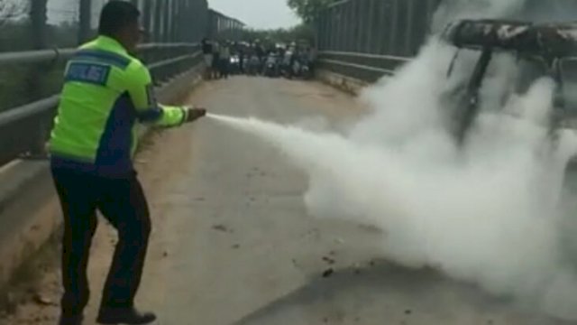 Petugas SAT PJR Ditlantas Polda Banten padamkan angkot yang terbakar. (Ist)