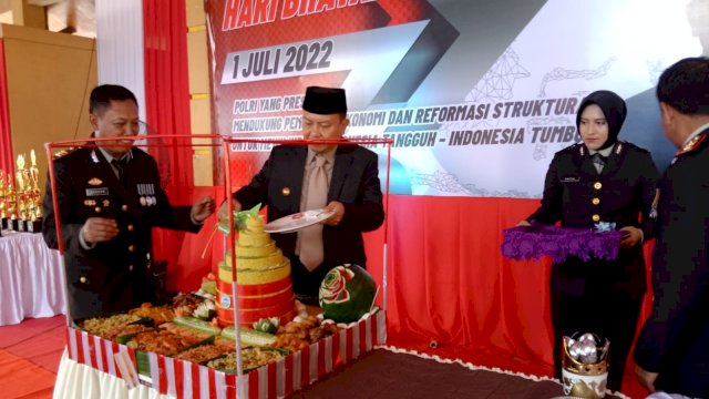 Bupati Selayar Basli Ali, memotong tumpeng pada Pelaksanaan Upacara HUT Bhayangkara Ke-76 di Lapangan Pemuda Benteng Kabupaten Kepulauan Selayar. (Istimewa)