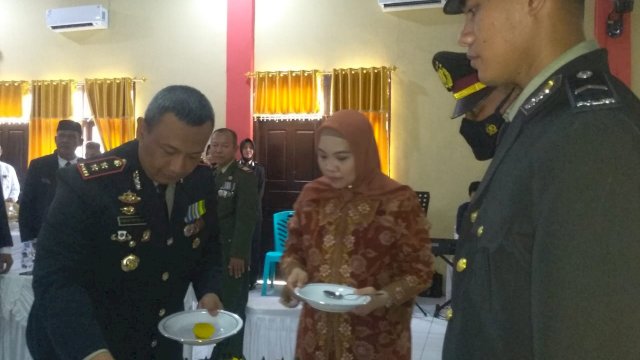 Kapolres Wakatobi AKBP Dodik Tatok Subiantoro, menyerahkan nasi tumpeng kepada Personil termuda Bripda La Ode Samsir dan personil tertua AKP Idris Unga, Selasa (05/07/2022). (Foto: Gayus Irwandi/Republiknews.co.id)