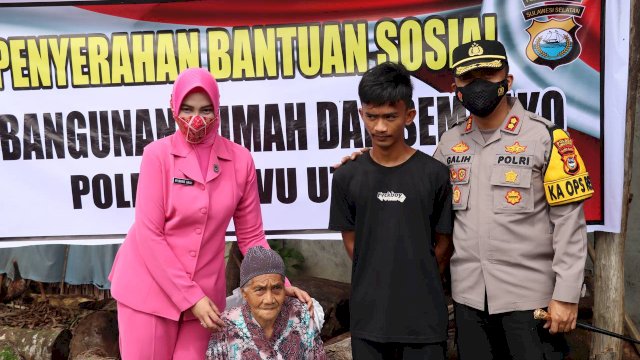 Kapolres Luwu Utara AKBP Galih Indragiri, didampingi isteri menyerahkan bantuan pembangunan rumah kepada nenek Tenri warga dusun Tambak Sari Kecamatan Mappedeceng, Kamis (14/07/2022). (Istimewa)