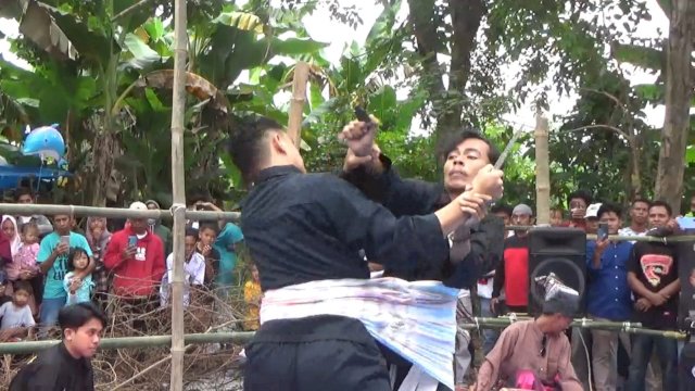 Dua orang pemuda sedang melakukan tarung sarung saat Festival Budaya di Galesong Selatan, Kabupaten Takalar, Kamis (14/07/2022). (Istimewa)