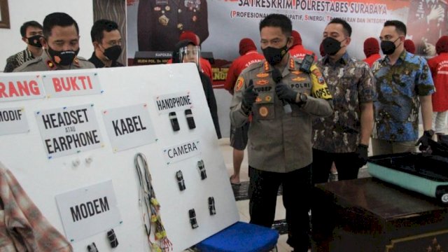 Kapolrestabes Surabaya Kombes Pol Akhmad Yusep Gunawan, saat press confrence menerangkan skema alat elektronik yang digunakan joki ujian tertulis berbasis komputer ini. (Istimewa)