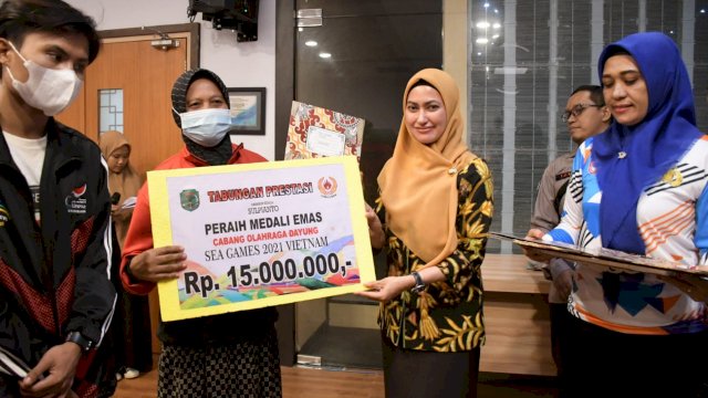 Bupati Luwu Utara Indah Putri Indriani, menyerahkan tabungan secara simbolis kepada salah satu Atlet, Jumat (15/07/2022). (Istimewa)