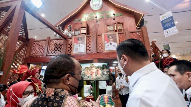 Bupati Gowa yang juga Sekjen APKASI Adnan Purichta Ichsan, saat memperlihatkan miniatur Balla Lompoa kepada salah satu pejabat saat mengunjungi stand Kabupaten Gowa di APKASI Otonomi Expo 2022 di JCC, Jakarta Pusat, Rabu (20/07/2022). (Dok. Humas Gowa)