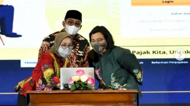 Menteri Keuangan dan Direktur Jenderal (Dirjen) Pajak Suryo Utomo (tengah) saat melihat proses penggunaan NIK menjadi NPWP dalam aplikasi pajak di sela-sela puncak perayaan Hari Jadi Pajak 2022. (Dok. Humas DJP Sulselrabar)