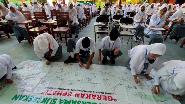 Puluhan siswa di SMKN 5 menandatangani spanduk srbagai komitmen untuk tidak melakukan perkawinan diusia muda. (Istimewa)