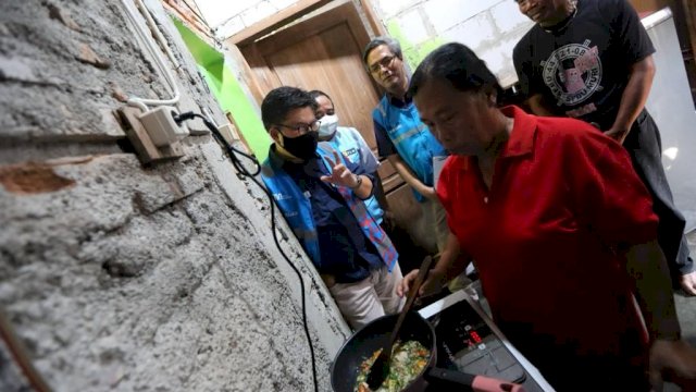 Petugas PLN saat mempraktekkan penggunaan kompor Induksi di rumah salah satu warga Kota Surakarta. (Istimewa)