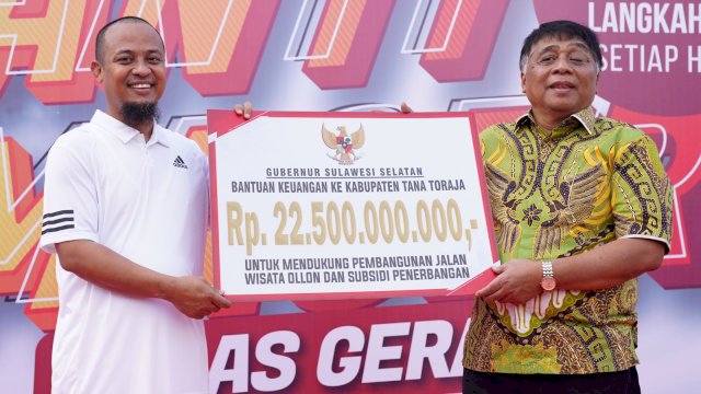 Gubernur Sulsel Andi Sudirman Sulaiman, menyerahkan bantuan keuangan secara simbolis kepada Bupati Tana Toraja Theofilus Allorerung, Sabtu (23/07/2022). (Istimewa)