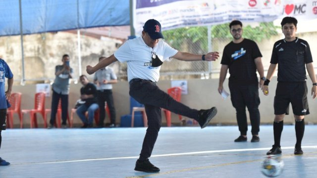 Direktur Utama PDAM Kota Makassar Beni Iskandar, menendang bola pertama saat membuka turnamen Futsal dalam rangka memperingatiHUT ke-98 PDAM Kota Makassar. (Istimewa)