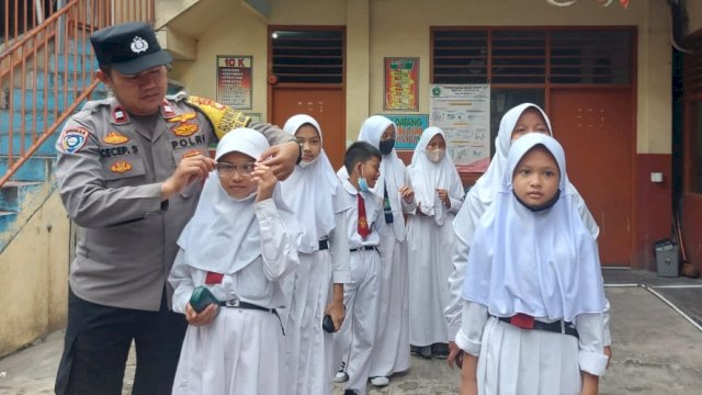 Bhabinkamtibmas Kelurahan Roa Malaka Polsek Tambora, menyerahkan Secara Simbolis Kacamata Siswa Dari Kapolsek Tambora. (Ist)