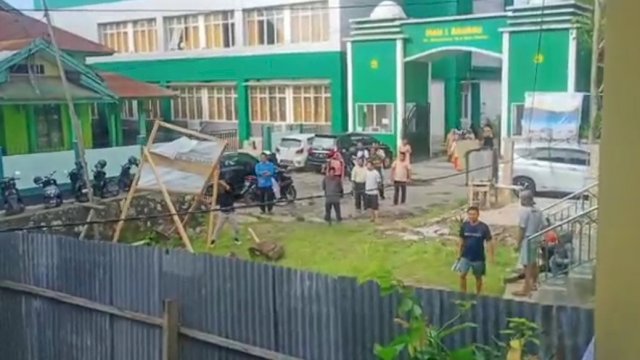 Tangkapan layar video puluhan warga bersama Alumni MAN 1 Baubau, membongkar Papan informasi yang dipasang oleh pengadilan Agama (PA) Baubau. (Istimewa)
