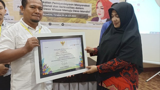 Kepala Disparbud Gowa Tenriwati Tahrir saat menyerahkan penghargaan Kemenparekraf RI kepada pengelola Desa Wisata Manuju, di sela-sela Pelatihan Pengelolaan Desa Wisata di Hotel Aryaduta Makassar, Kamis (28/07). (Chaerani/Republiknews.co.id)