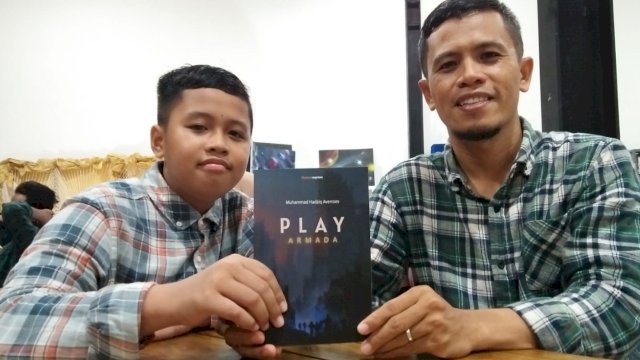Hadziq Averrose bersama Ayahnya memegang buku Novel Play Armada. (Foto: Rahim Arza/Republiknews.co.id)