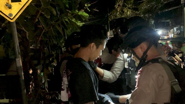 Tim Thunder Polda Sulsel saat menggeledah dua pemuda mencurigakan di Jalan Dangkot, Kota Makassar, Kamis (04/08/2022). (Istimewa)