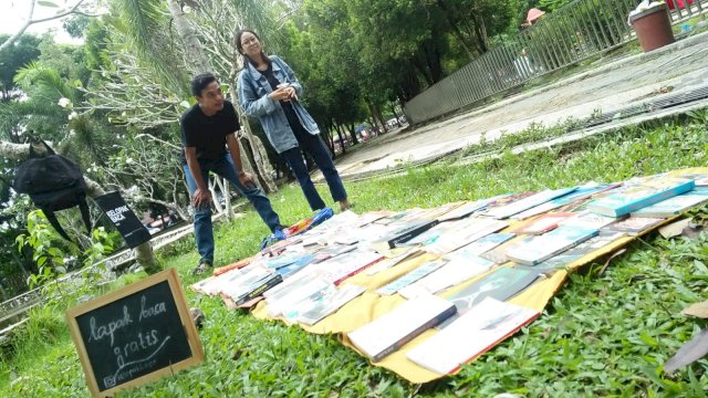 Dina dan Fahmi, pelopor Kelopak Baca tengah menunggu pengunjung Taman Kamboja Banjarmasin. (Foto: Rahim Arza)