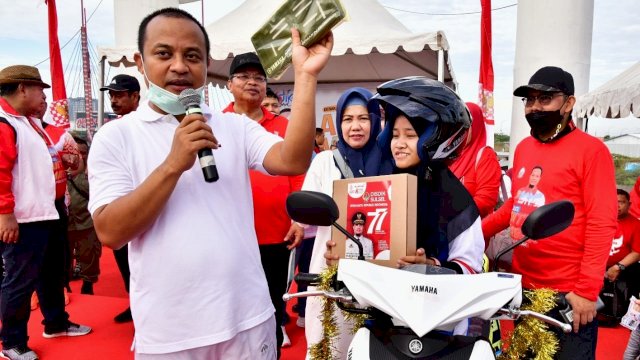 Gubernur Sulsel Andi Sudirman Sulaiman, saat menyerahkan hadiah motor hasil undian Gerakan 'Sulsel Anti Mager' kepada salah satu pelajar. (Istimewa)