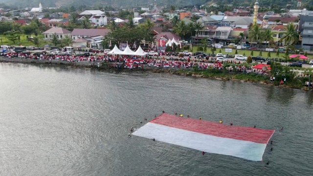Bendera sang saka merah putih ukuran raksasa dikibarkan di Teluk Mamuju, Sabtu, 13 Agustus 2022. (Istimewa)
