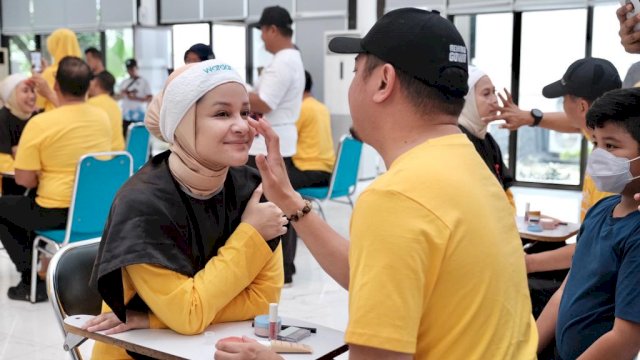 Bupati Gowa Adnan Purictha Ichsan, terlihat antusias mendandani istri saat ikut meramaikan Lomba Make Up Pasangan dalam rangka memeriahkan HKG ke-55 Tahun. (Dok. Humas Gowa)
