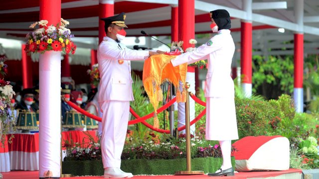 Gubernur Sulsel Andi Sudirman Sulaiman, menyerahkan bendera merah puti kepada pembawa baki Paskibraka, Rabu (17/08/2022). (Istimewa)