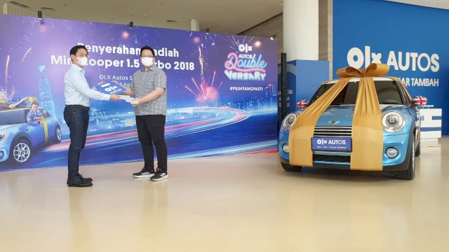 Chief OperatingOfficer OLX Autos Indonesia, Hendri Tadjuni (kiri) saat menyerahkan kunci mobil secara simbolik oleh pemenang OLX Autos Doubleversary Bhinawan Whendy Wicaksono di OLX Autos BSD Tangerang Selatan, Selasa, 9 Agustus 2022 lalu. (Dok. OLX Autos Indonesia)
