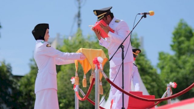 Ket; Bupati Soppeng HA.Kaswadi Razak saat menyerahkan Bendera merah putih untuk dikibarkan. (Istimewa)