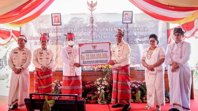 Gubernur Sulsel Andi Sudirman Sulaiman, menyerahkan secara simbolis bantuan keuangan kepada Bupati Tana Toraja Theofilus Allorerung. (Istimewa)