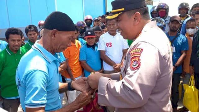 Kapolres Muna, AKBP Mulkaifin saat membagikan bingkisan kepada salah satu buruh Pelabuhan Nusantara Raha. (Rustam/Republiknews.co.id)