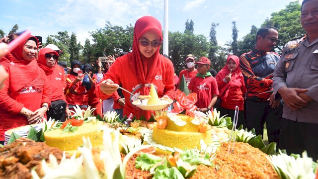Bupati Luwu Utara yang juga Ketua PMI Luwu Utara Indah Putri Indriani, memotong tumpeng perayaan HUT ke-77 PMI. (Istimewa)