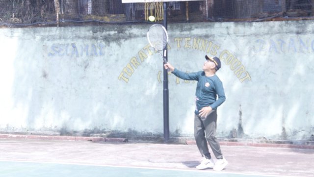 Bupati Jeneponto Iksan Iskandar memukul bola tenis saat melakoni pembukaan turnamen tenis Dandim Cup 2022. (Istimewa)